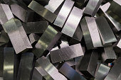 a pile of shiny faceted steel blocks - full frame close-up with selective focus