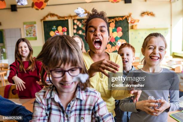 school kids feeling frustrated of using papers on a class and throwing them towards the camera. - shouting in class stock pictures, royalty-free photos & images