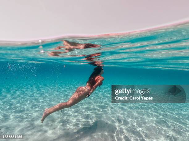 woman exploring the sea while snorkeling in summer day. - beach sand and water hawaii stock-fotos und bilder