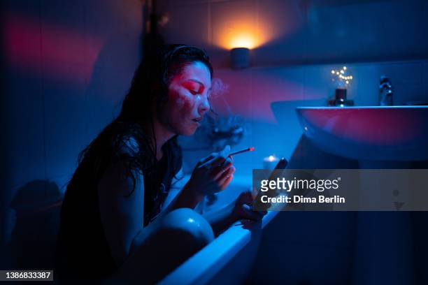 sad girl drunk in bath smoke jealous follow ex boyfriend in social media, communicate in dating app - former stock pictures, royalty-free photos & images