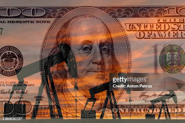oil pump on the background of 100 dollar bill. world oil industry - oil pump stockfoto's en -beelden