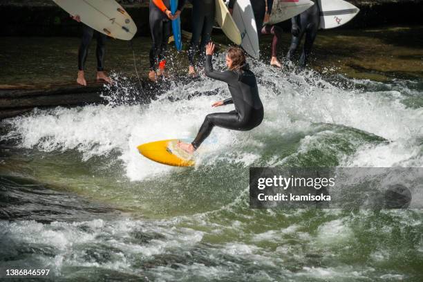 surfing man on the eisbach in munich, germany - munich surfing stock pictures, royalty-free photos & images