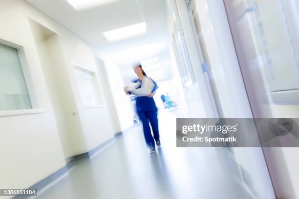 ethnic female medical nursing staff in scrubs in modern hospital recovery center - hospital blurred motion stock pictures, royalty-free photos & images