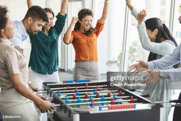 colleagues playing table football - playing board games stock pictures, royalty-free photos & images