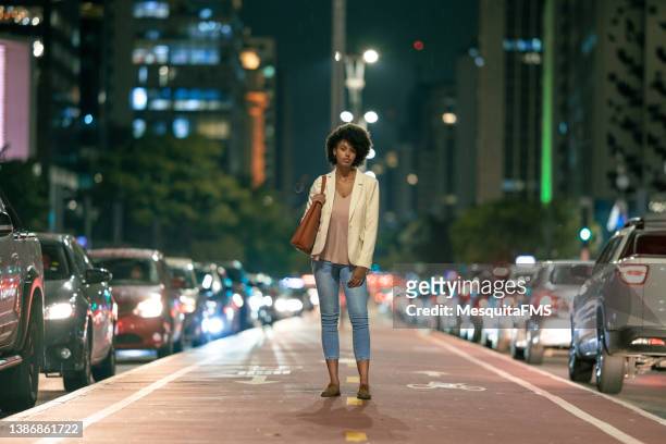 woman walking on avenida paulista at night - rainy day in sao paulo stock pictures, royalty-free photos & images