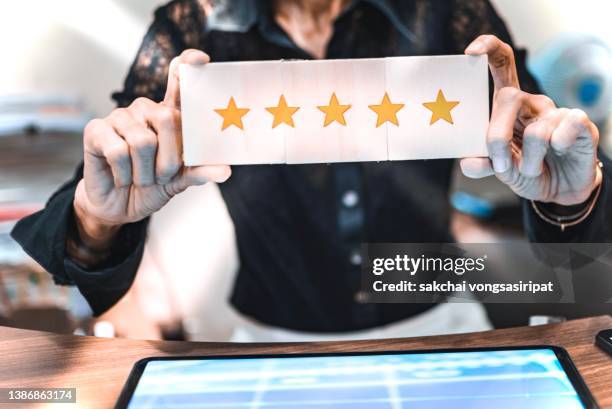 business woman holding five gold star - testimonial stock pictures, royalty-free photos & images