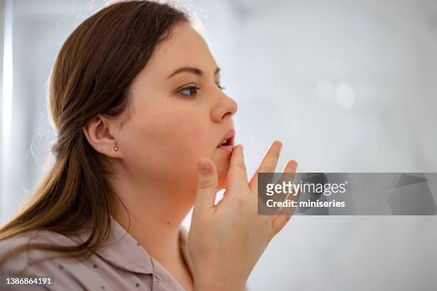 portrait of a woman touching her lip - human lips bildbanksfoton och bilder