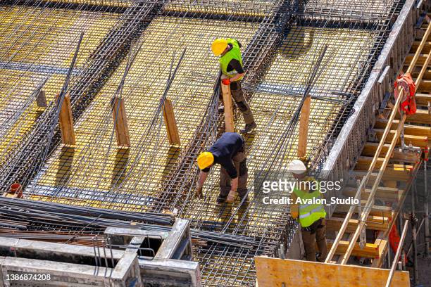 Workers make molds for reinforced concrete from reinforcing bars