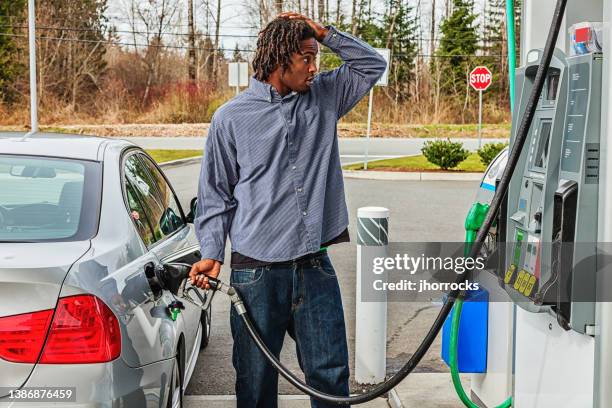 junger mann an der tankstelle unter schock über verkaufspreis - usa cars stock-fotos und bilder