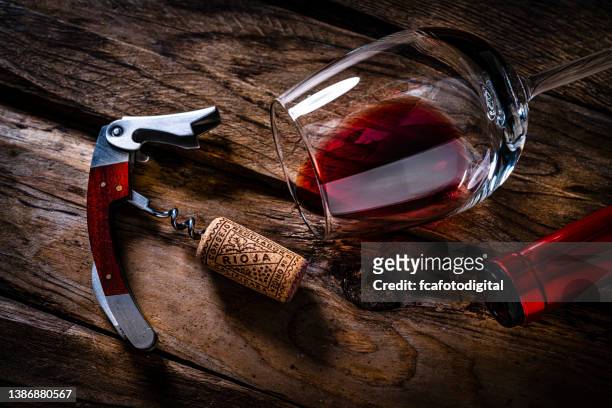 overhead view of a red wine bottle, cork stopper, corkscrew and wineglass - wine cork stockfoto's en -beelden