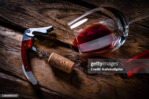 overhead view of a red wine bottle, cork stopper, corkscrew and wineglass - cork stopper 個照片及圖片檔