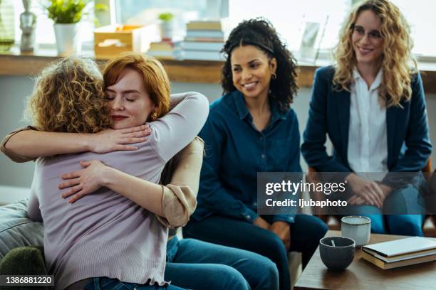 mutter und tochter umarmen sich bei einer psychotherapie für familien - family therapy stock-fotos und bilder