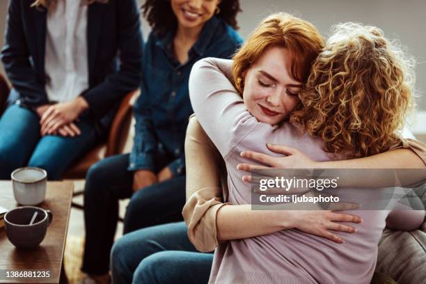 hugging during group therapy session - addiction recovery stock pictures, royalty-free photos & images