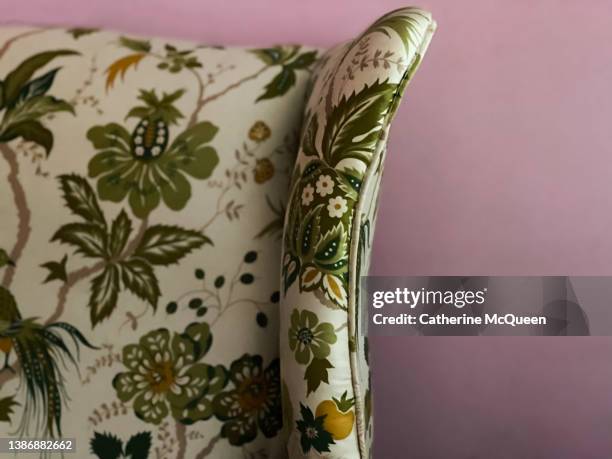 cozy high back wing chair with pretty botanical print upholstery against soothing lavender colored wall - upholstry stockfoto's en -beelden