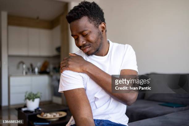 jovem afro-americano se sentindo mal em casa - no ombro - fotografias e filmes do acervo