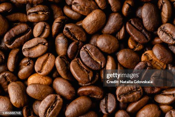 closeup of dark roasted coffee arabica beans with smooth aroma and ripe taste - arabica kaffee getränk stock-fotos und bilder