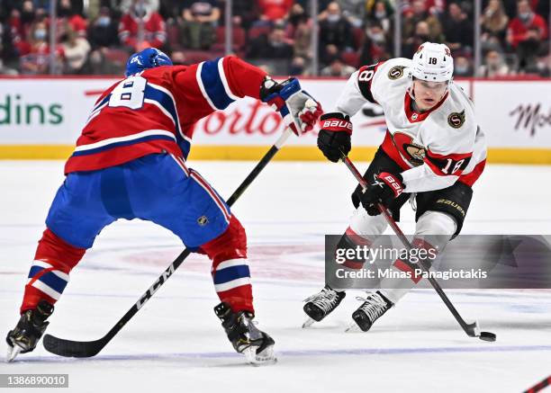 Tim Stützle of the Ottawa Senators skates the puck against Christian Dvorak of the Montreal Canadiens during the first period at Centre Bell on March...