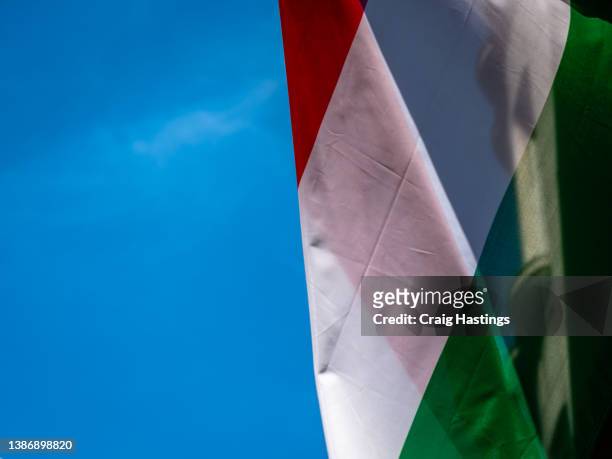 close up of colourful shot  hungarian  flag proudly flying in the wind outside government embassy style building. - ungarn stock-fotos und bilder