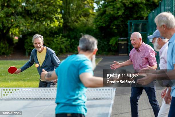 playing and practicing ping pong - friends table tennis stock pictures, royalty-free photos & images