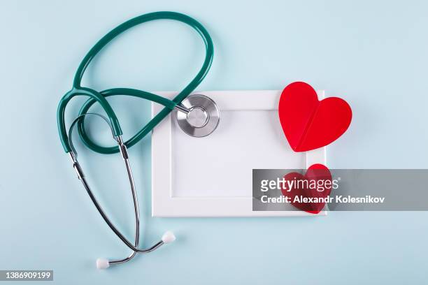 nurses day concept. medical stethoscope, two red hearts. healthcare medicine concept. flat lay. - annual global charity day stockfoto's en -beelden