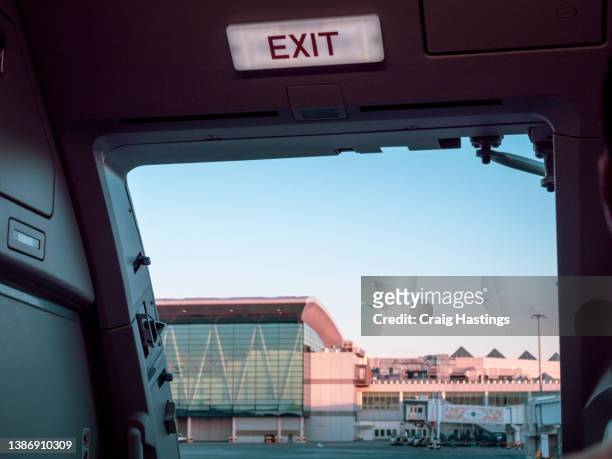 close up shot of sign in airplane near emergency exit doors - airplane open door stockfoto's en -beelden