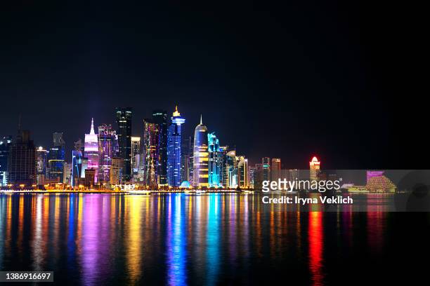 the skyline of doha city center after sunset, qatar. qatar welcomes you! - international soccer event stock pictures, royalty-free photos & images