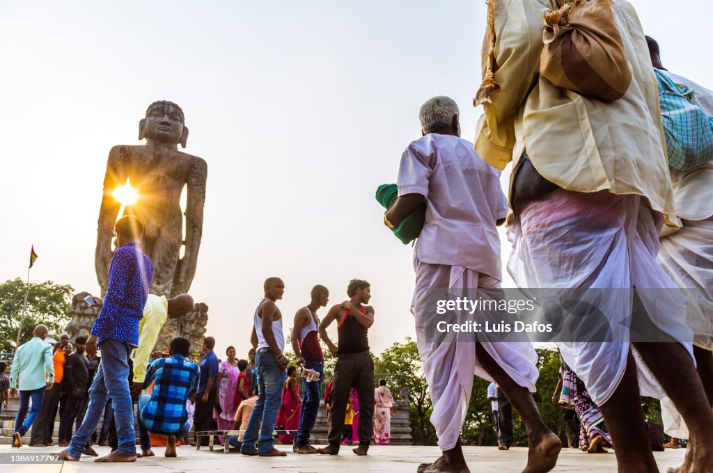 Sunset view of the 12 m high Bahubali statue surrounded by pilgrims.