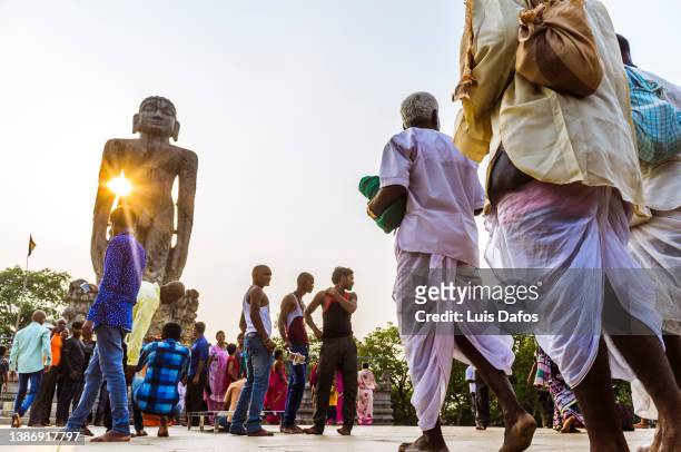 sunset view of the 12 m high bahubali statue surrounded by pilgrims. - digambara stockfoto's en -beelden