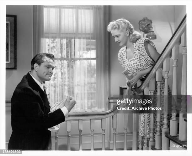 Red Skelton speaks with Marilyn Maxwell on stairs in a scene from the film 'The Show-Off', 1946.
