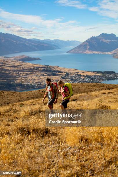 the remarkables male female team hiking outdoors otago - lake wakatipu stock pictures, royalty-free photos & images