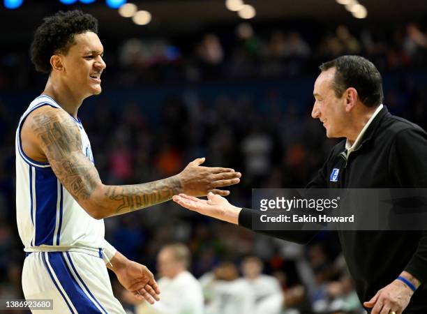 Paolo Banchero high fives head coach Mike Krzyzewski of the Duke Blue Devils as the game against the Michigan State Spartans comes to a close in the...