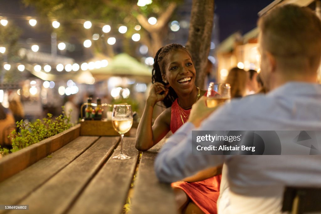 Couple drinking wine together outdoors at night