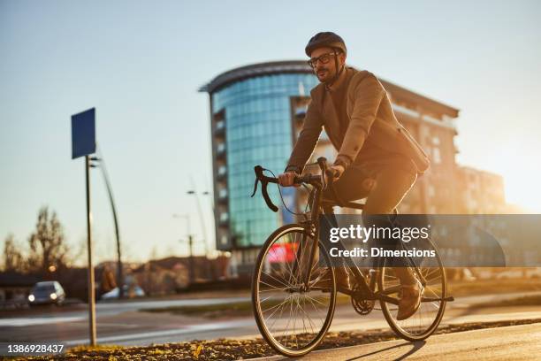 young stylish businessman going to work by bike - commuters stockfoto's en -beelden