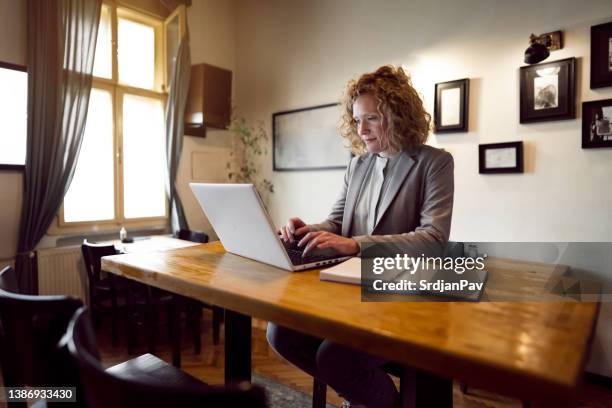 caucasian businesswoman working on laptop from restaurant - agenda meeting stock pictures, royalty-free photos & images