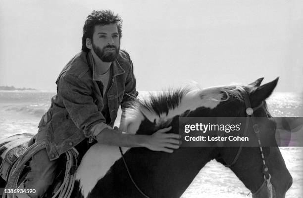 American musician, singer and songwriter, Kenny Loggins, rides his horse at the beach circa 1985 in Los Angeles, California.