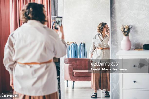 plus size woman choose fashioned dress in store. plus size women shopping. - mirror selfie stock pictures, royalty-free photos & images