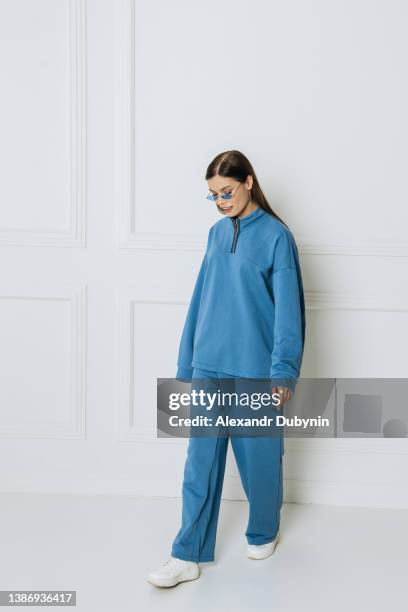 beautiful young woman model posing in studio in new clothes collection - tracksuit fotografías e imágenes de stock