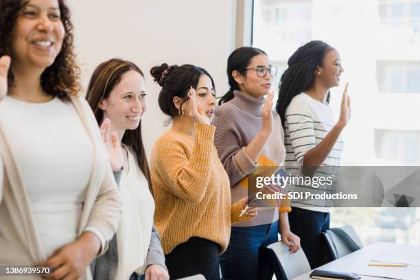 young women reciting pledge - citizenship ceremony stock pictures, royalty-free photos & images