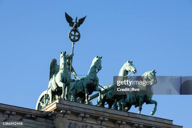 the quadriga statue on the brandenburg gate in berlin (germany) - quadriga statue brandenburg gate stock-fotos und bilder