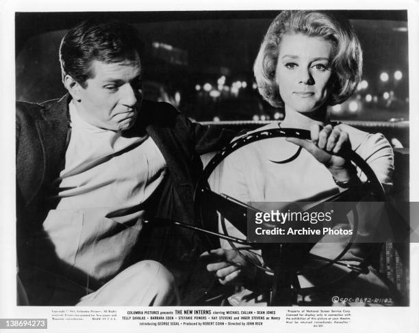 Michael Callan sitting with Inger Stevens as she drives in a scene from the film 'The New Interns', 1964.