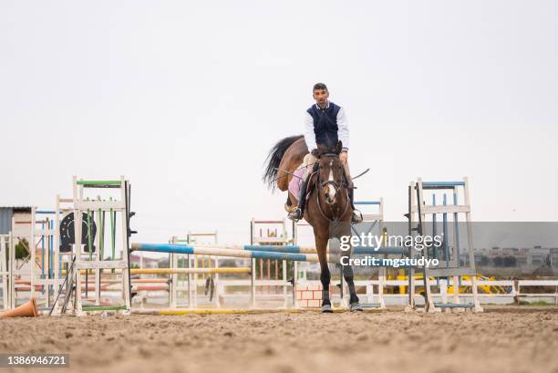 amateurreiter lässt hürde im springreitrennen fallen - equestrian show jumping stock-fotos und bilder