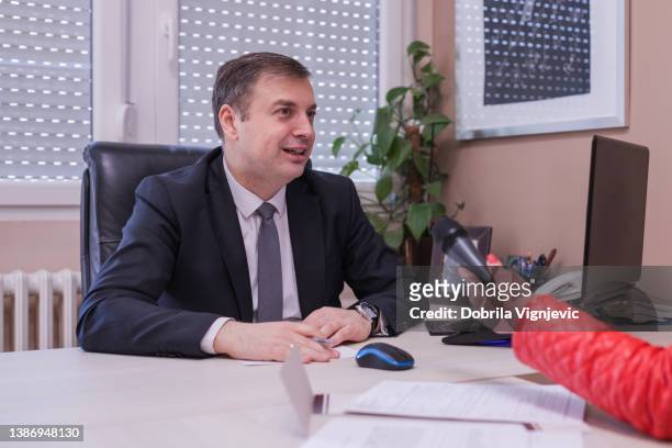 cheerful businessman having an interview at his place of work - media interview stock pictures, royalty-free photos & images