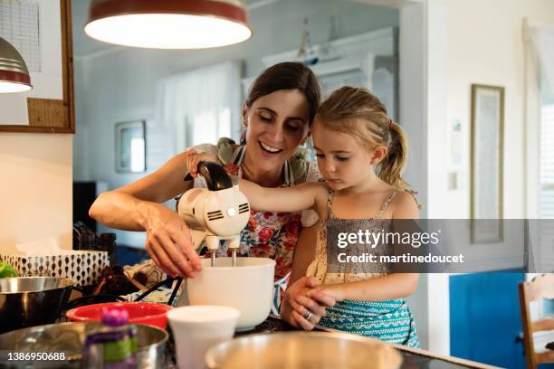 mother and young daughter baking a cake at home. - electric mixer stock pictures, royalty-free photos & images