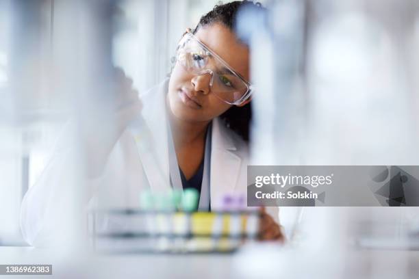 young female scientist working in laboratory - industria-farmaceutica fotografías e imágenes de stock