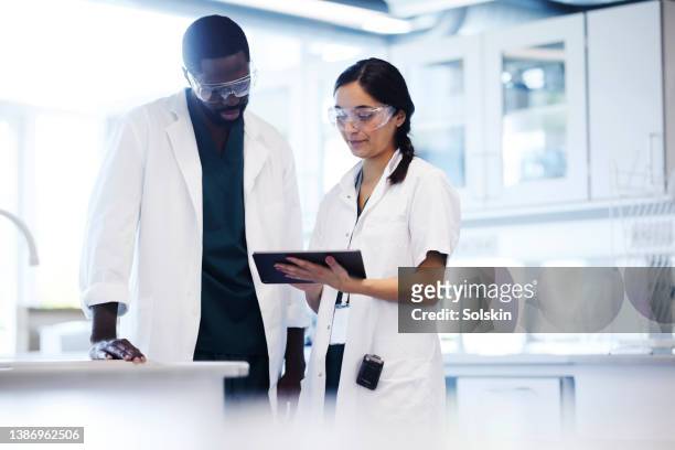 two scientists working together in laboratory - black woman in lab stock pictures, royalty-free photos & images