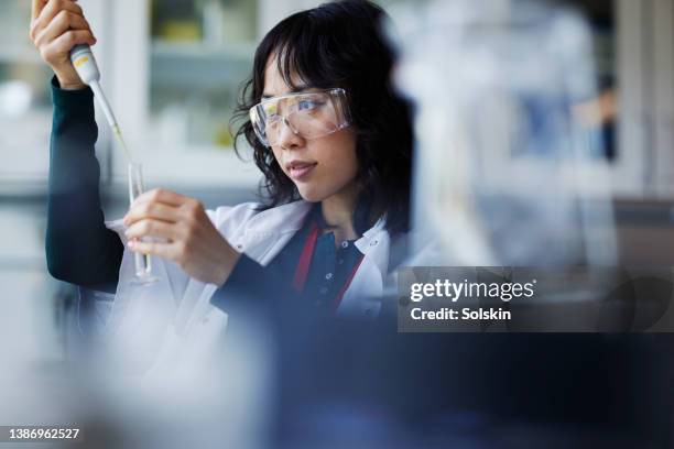 young female scientist working in laboratory - médica fotografías e imágenes de stock