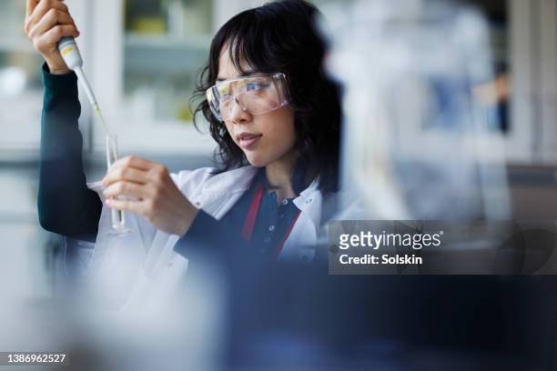 young female scientist working in laboratory - chemical imagens e fotografias de stock