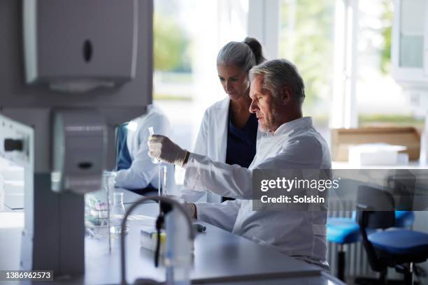 scientists working together in laboratory - old trying to look young stock pictures, royalty-free photos & images