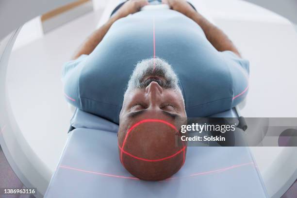 mature patient in medical x-ray scanner - cancer care stock pictures, royalty-free photos & images