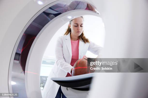 female radiologist helping patient in medical x-ray scanner - oncology bildbanksfoton och bilder